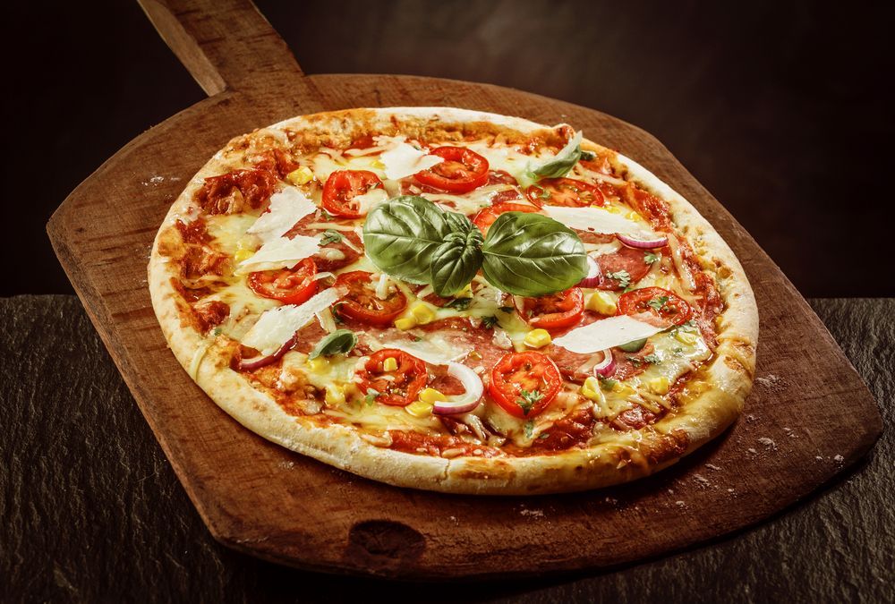 A Pizza is Sitting on a Wooden Cutting Board — Mumbo's Pizza'n'Pasta In Lismore, NSW