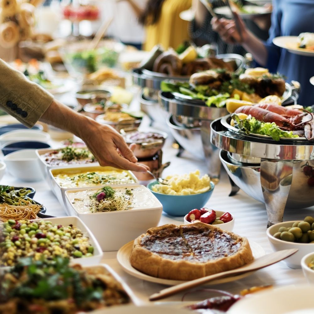 A Person is Picking Up Food From a Buffet Table — Mumbo's Pizza'n'Pasta In Lismore, NSW