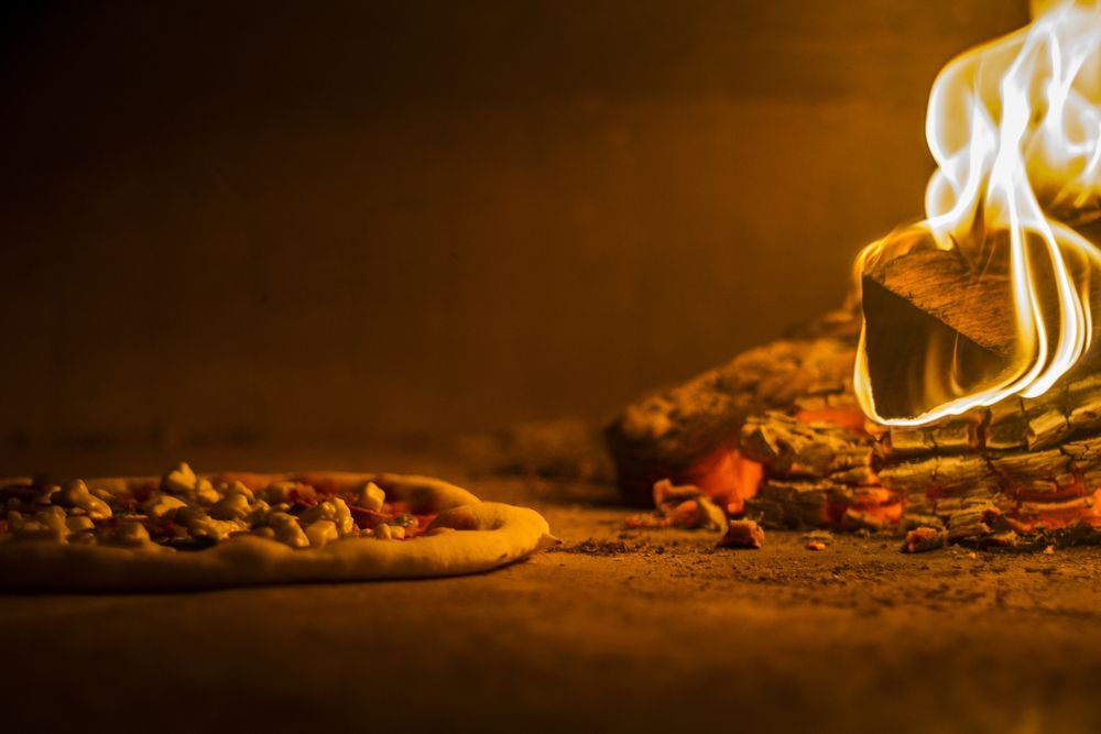 A Pizza is Being Cooked in a Wood Fired Oven — Mumbo's Pizza'n'Pasta In Lismore, NSW