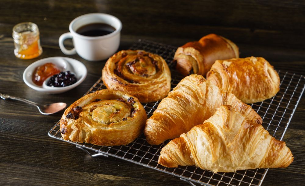 A Bunch of Pastries Are Sitting on a Cooling Rack Next to a Cup of Coffee — Mumbo's Pizza'n'Pasta In Lismore, NSW