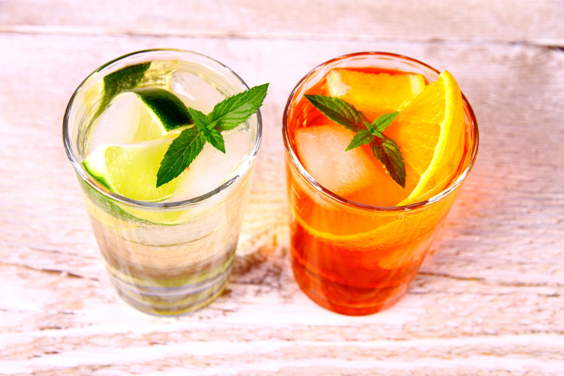 Two Glasses of Drinks With Ice and Mint Leaves on a Wooden Table — Mumbo's Pizza'n'Pasta In Lismore, NSW