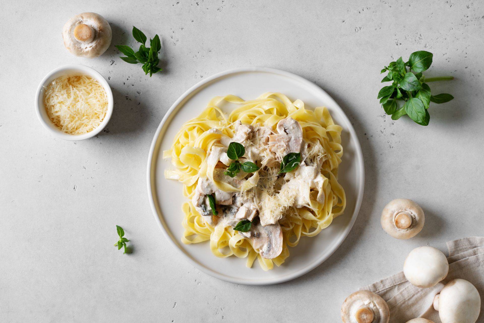 A Plate of Pasta With Mushrooms and Cheese on a Table — Mumbo's Pizza'n'Pasta In Lismore, NSW
