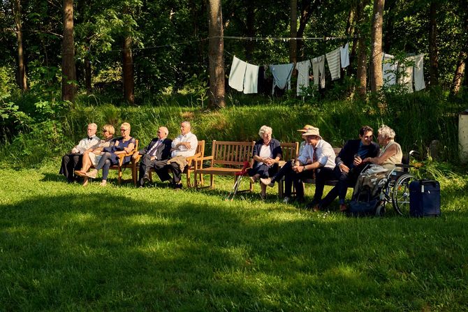 Alte Menschen sitzen bei einer Hochzeit in Brandenburg auf einer Parkbank. Hochzeitsfotograf Berlin