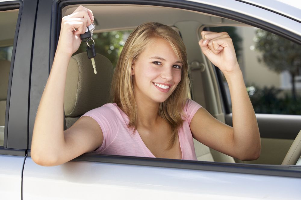 A girl with keys in her hand in the drivers seat just passed her license — Primera Driving School Darwin In Fannie Bay, NT