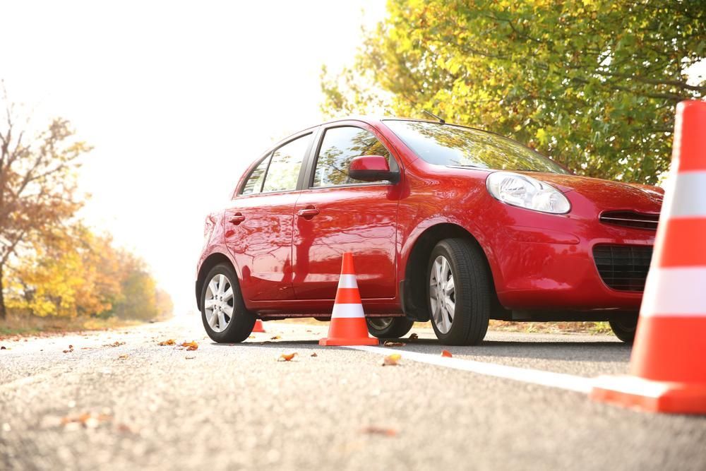 A Red Car Is Parked Next To Traffic Cones — Primera Driving School Darwin In Berrimah, NT
