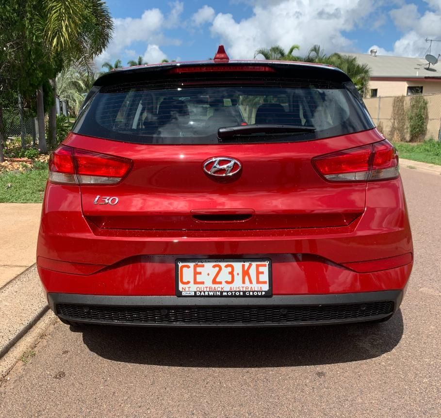 A Red Hyundai Hatchback Is Parked On The Side Of The Road — Primera Driving School Darwin In Anula, NT