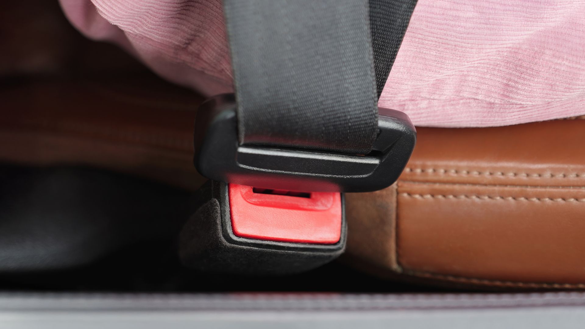 Close-up of fastened seatbelt on luxury car seat.