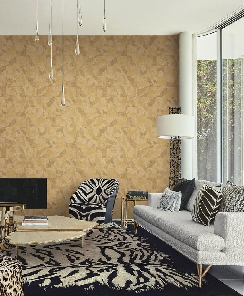 Una cassettiera bianca con una lampada, accanto a una sedia bianca e una carta da parati a motivi.