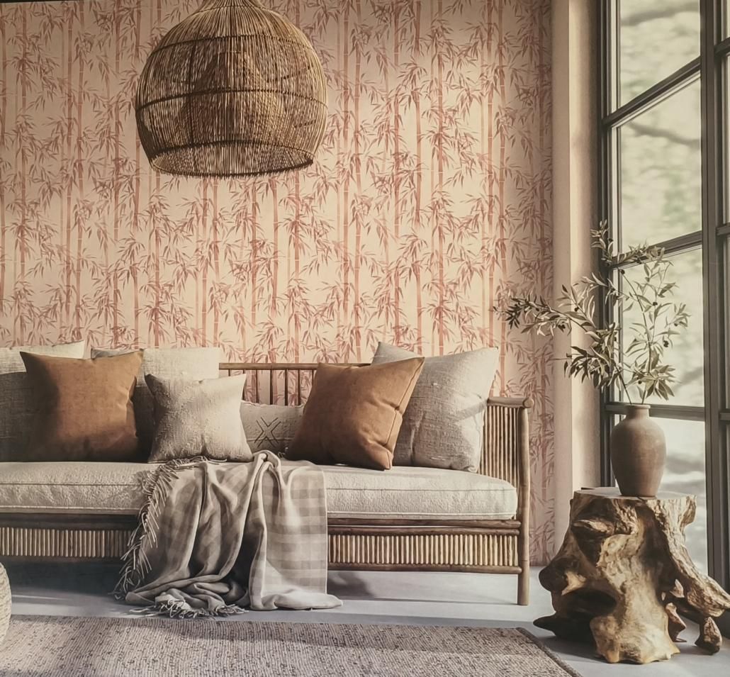 Soggiorno boho con divano, carta da parati a fantasia, lampadario intrecciato e ampia finestra.