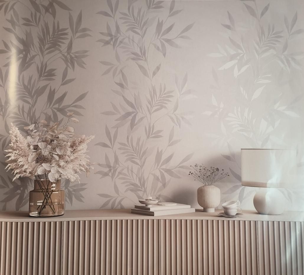 Carta da parati floreale dai toni neutri con mensola decorativa su cui sono appoggiati vasi, libri e una composizione floreale secca.