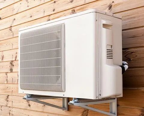 A White Air Conditioner Is Mounted On A Wooden Wall — South Coast Refrigeration & Air Conditioning In Bomaderry, NSW