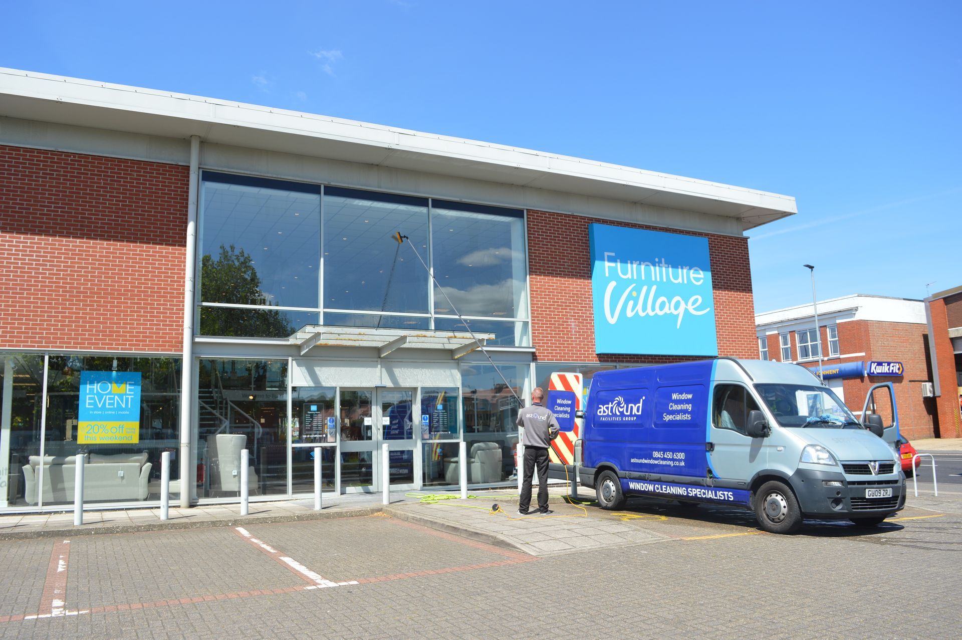 Picture of an Window cleaning Van & operator using pure water reach & wash pole to clean shop front windows