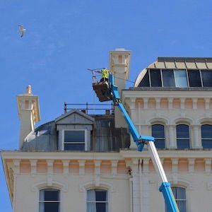 Man on a High access lift performing high rise window cleaning on a hotel