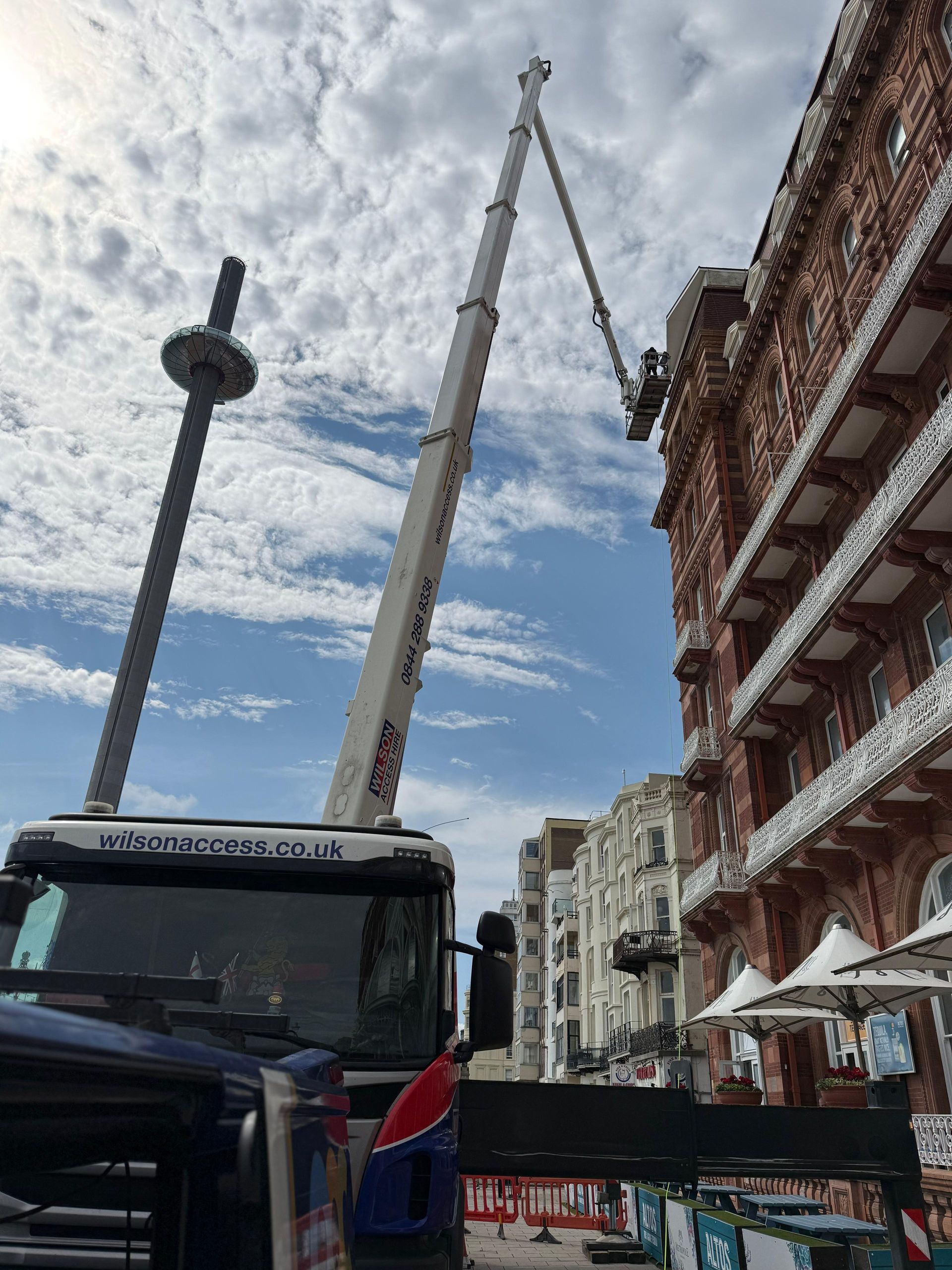 Man on a High access lift performing high rise commercial window cleaning Brighton seafront