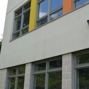 Building exterior with gray windows, yellow and orange accents.