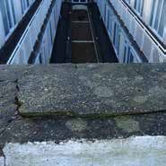 Looking down into a narrow courtyard between tall buildings; rough stone in the foreground, windows in the background.