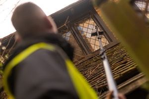 Man using telescopic pole with pure water residential window cleaning