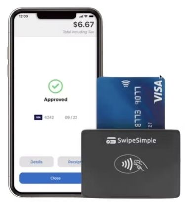 Smartphone showing an approved payment with a credit card being swiped on a SwipeSimple reader.