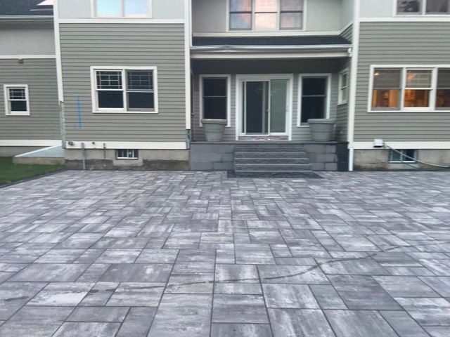 A large house with a brick driveway in front of it.