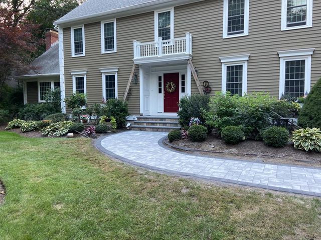 A large house with a walkway leading to the front door.