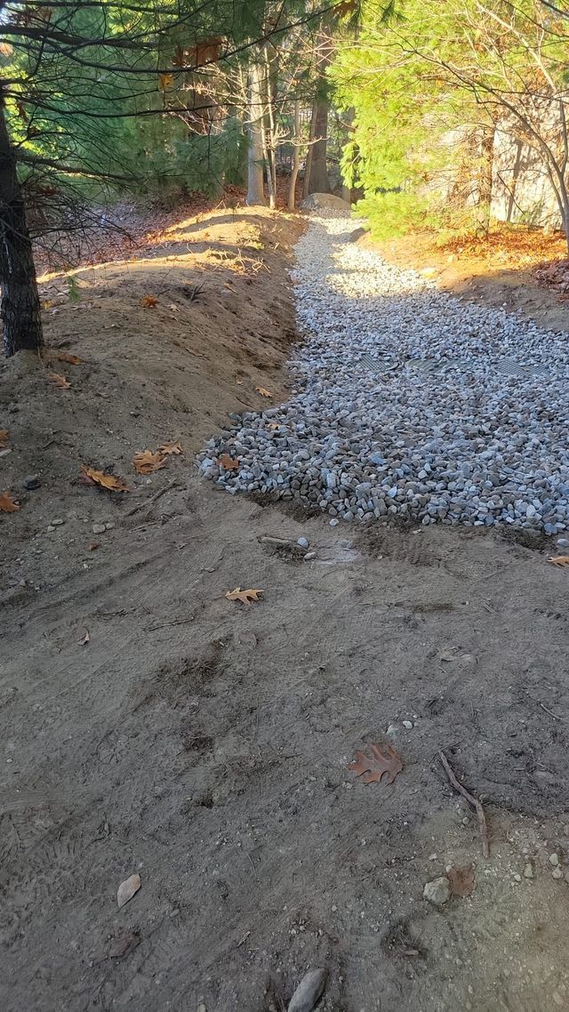 A pile of gravel is sitting on top of a dirt road.