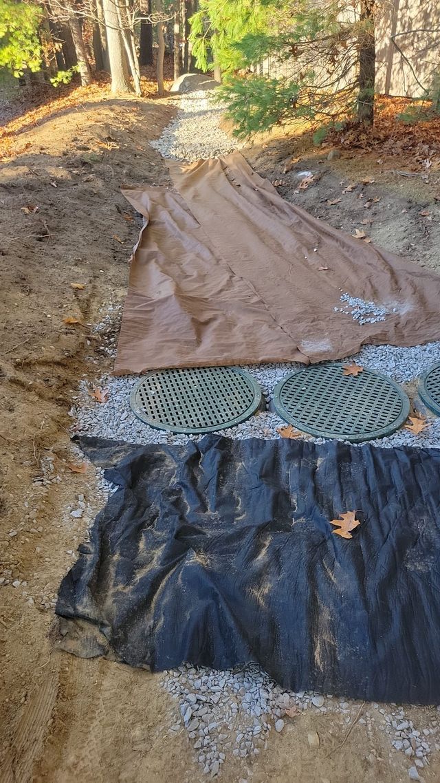 A pile of tarps sitting on top of a dirt road.