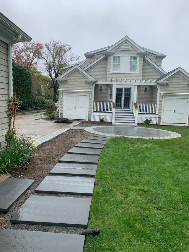 There is a walkway leading to the front of the house.