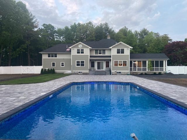 A large house with a large swimming pool in front of it.