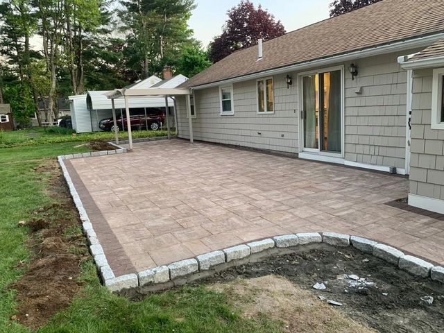 A patio is being built in front of a house.