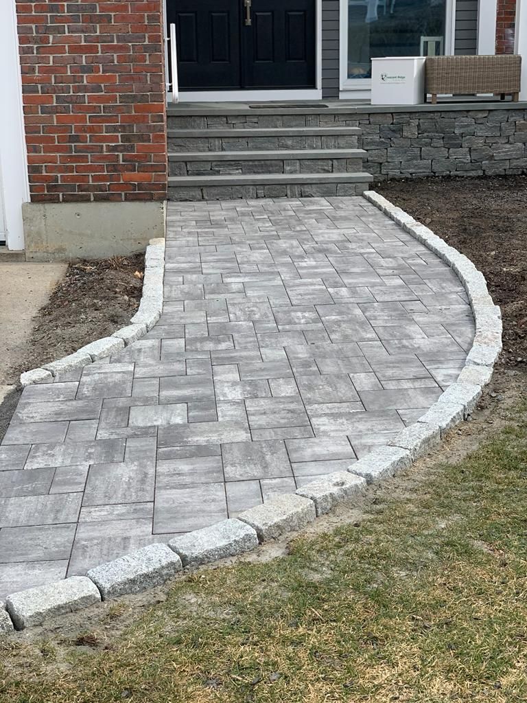 A brick walkway leading to the front door of a house.