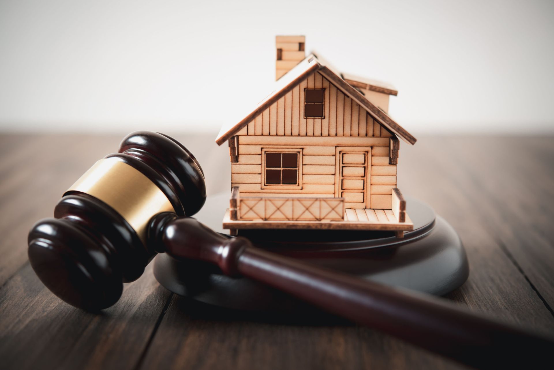 a wooden house is sitting on a wooden table next to a wooden gavel .