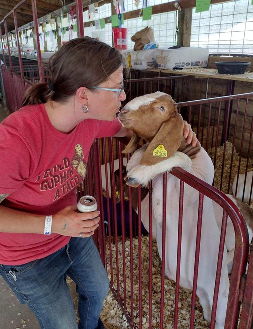 Christine kissing a goat during a festival
