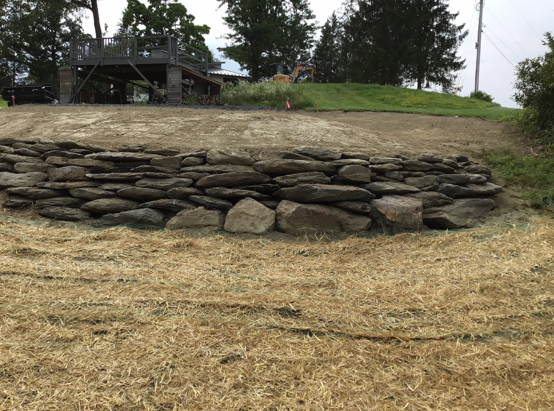 A large pile of rocks is sitting in the middle of a dirt field.