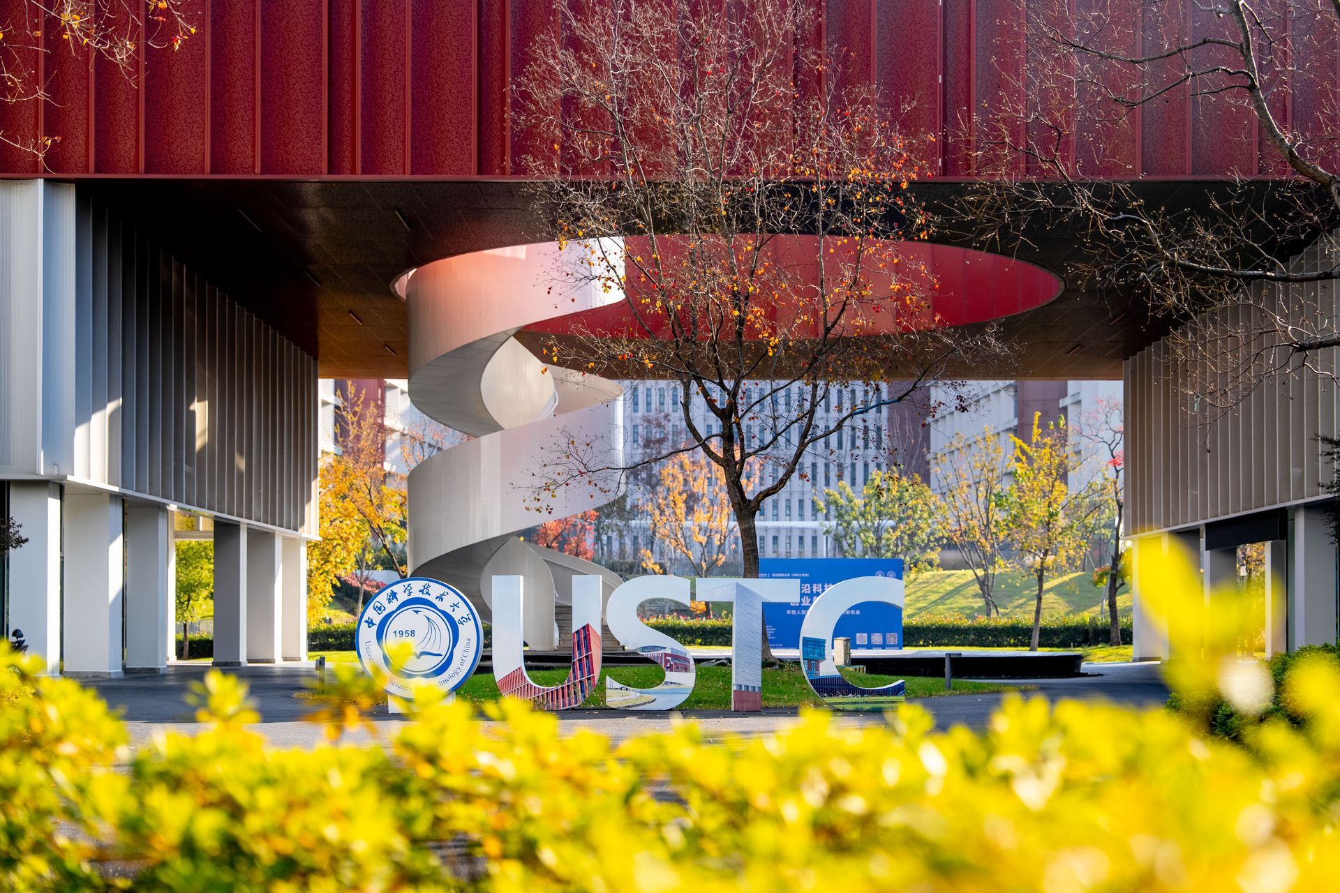 A modern university entrance with a spiral sculpture, the