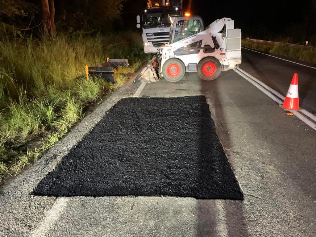 Bobcat is Laying Asphalt on the Side of a Road at Night — JP Civilworx Pty Ltd in Singleton, NSW