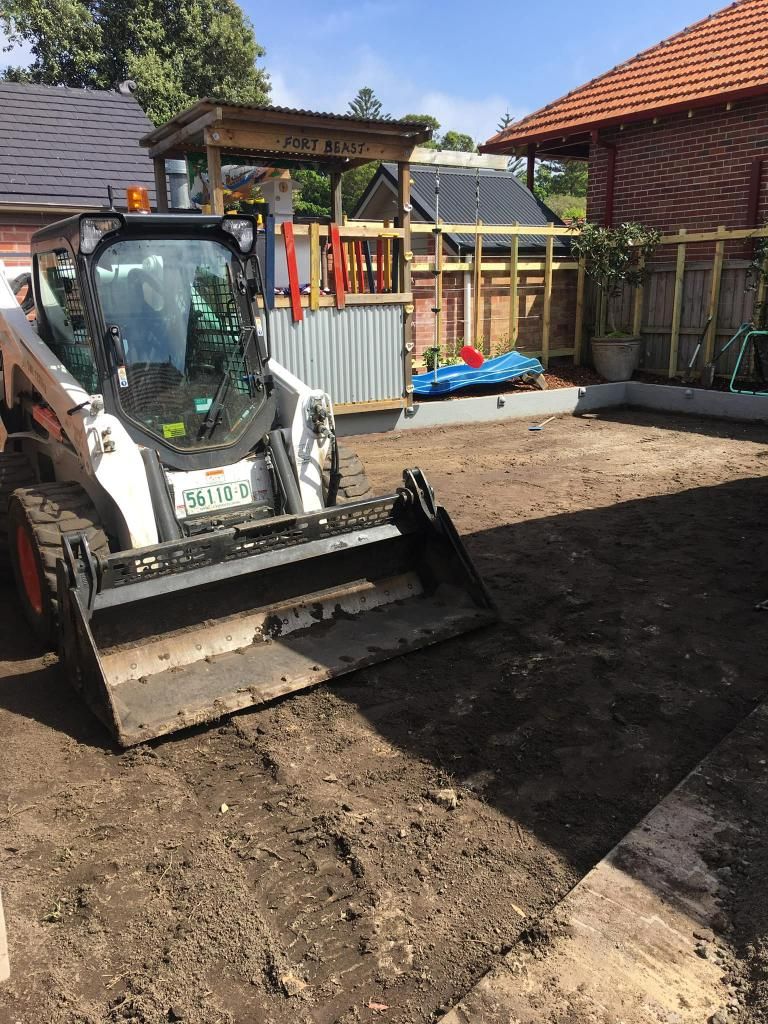 Bobcat is Sitting in the Dirt in Front of a House — JP Civilworx Pty Ltd in Maitland, NSW