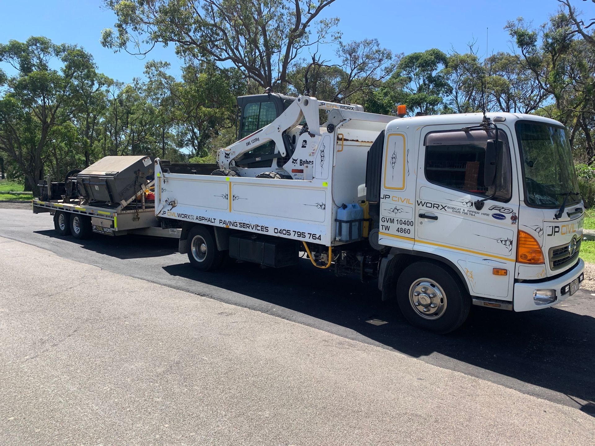 A white truck with a trailer attached to it is parked on the side of the road — JP Civilworx Pty Ltd in Eraring, NSW
