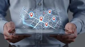 Persona sosteniendo una tableta que muestra un mapa con varios marcadores de ubicación rojos.