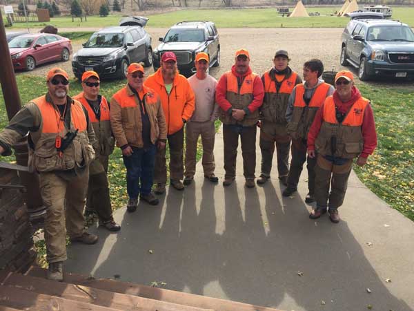 A group of people wearing orange vests are posing for a picture.