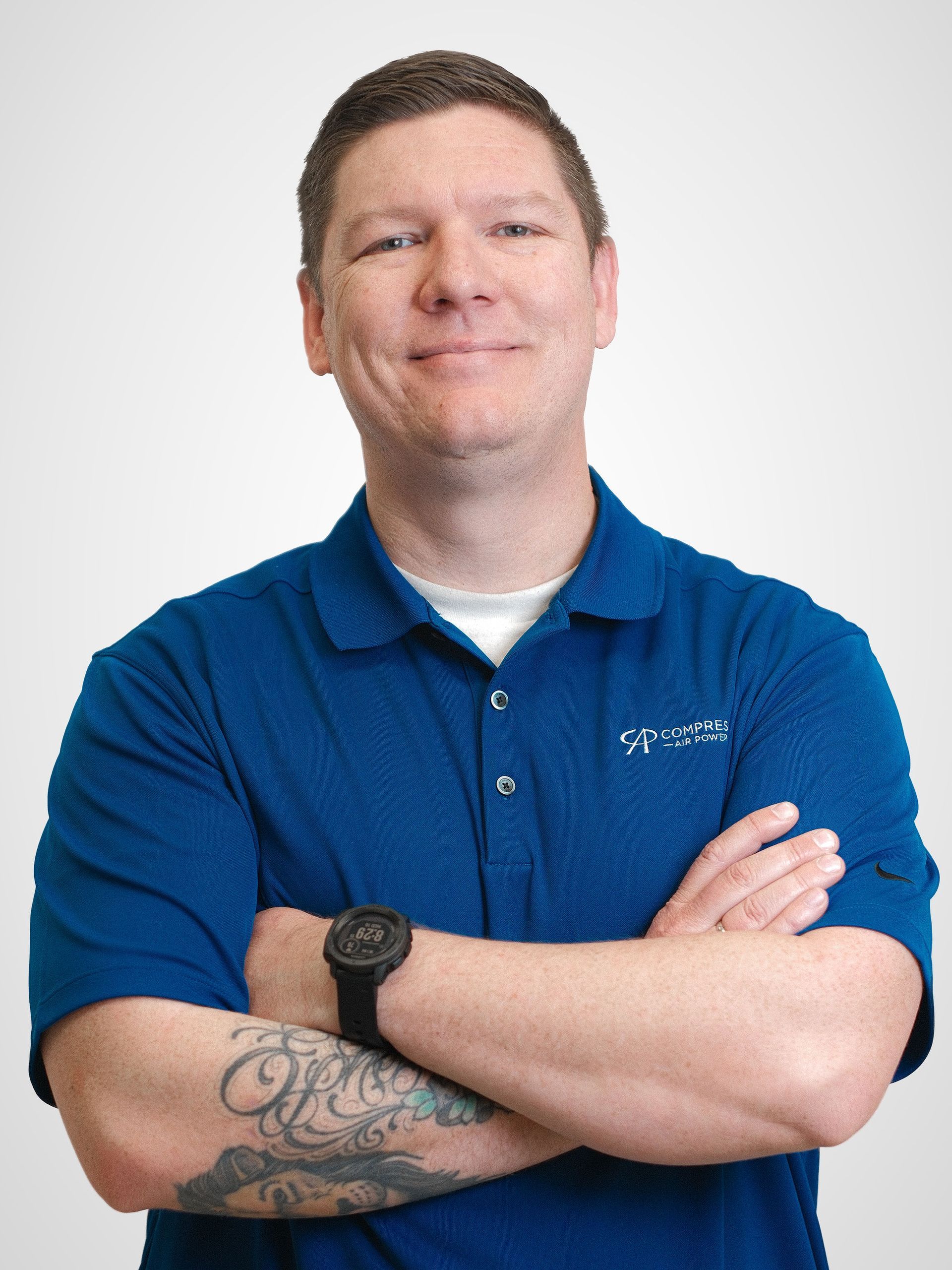 A man in a blue shirt is smiling for the camera