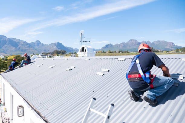 A man is kneeling on the roof of a building.