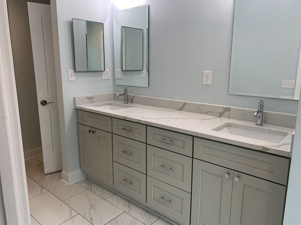 Bathroom with light gray vanity, white marble countertop, and light blue walls.