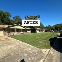A house with a lush green lawn in front of it.