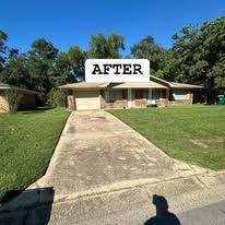 A picture of a house and driveway after being cleaned.