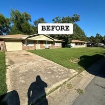 A before picture of a house with a concrete driveway.
