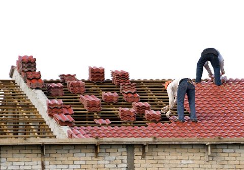 two workers installing the tile roof