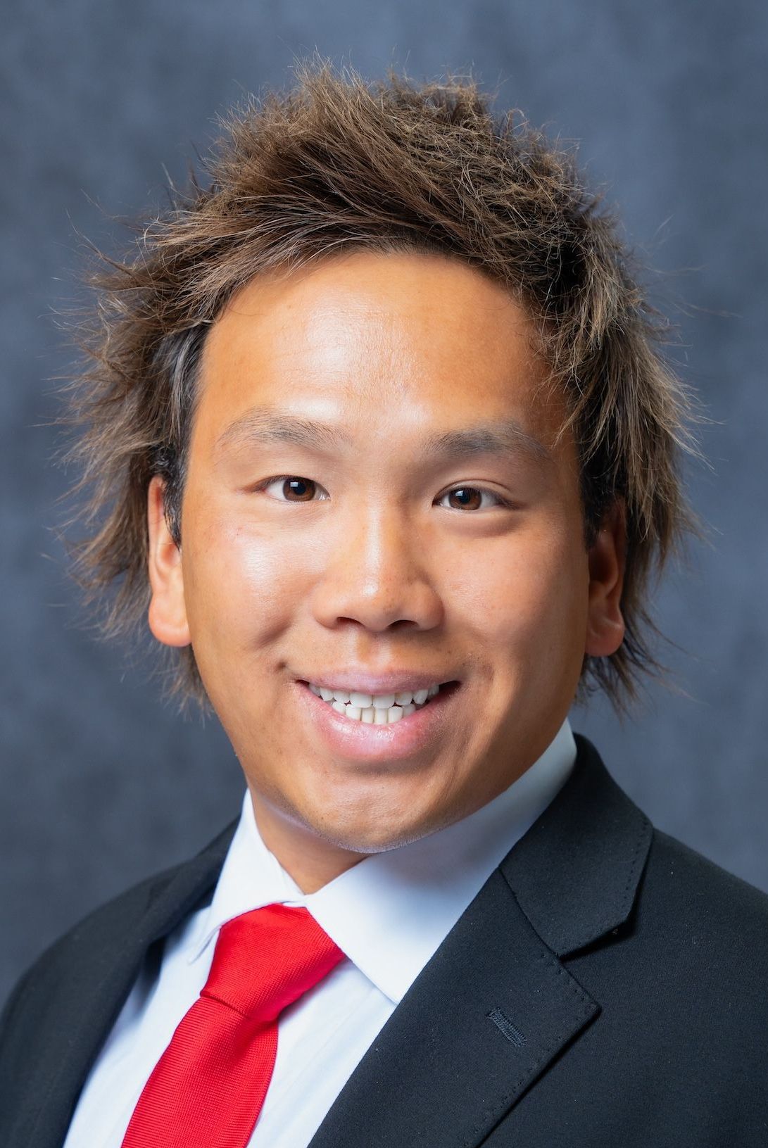A man in a suit and tie is smiling for the camera.
