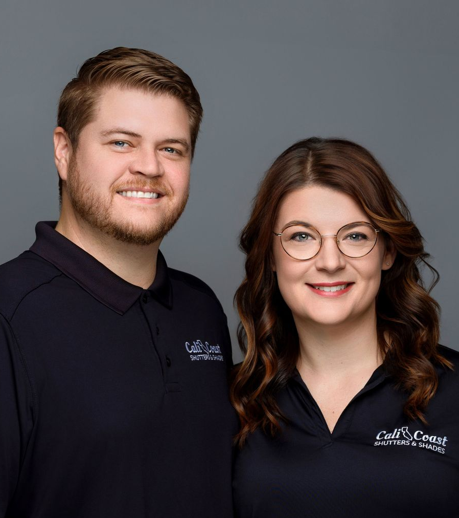 Man and woman smiling, wearing black shirts with logo 