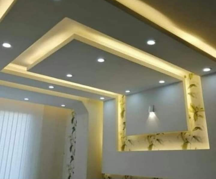 Techo moderno con luces empotradas y detalles LED cálidos en el interior de una sala de estar.