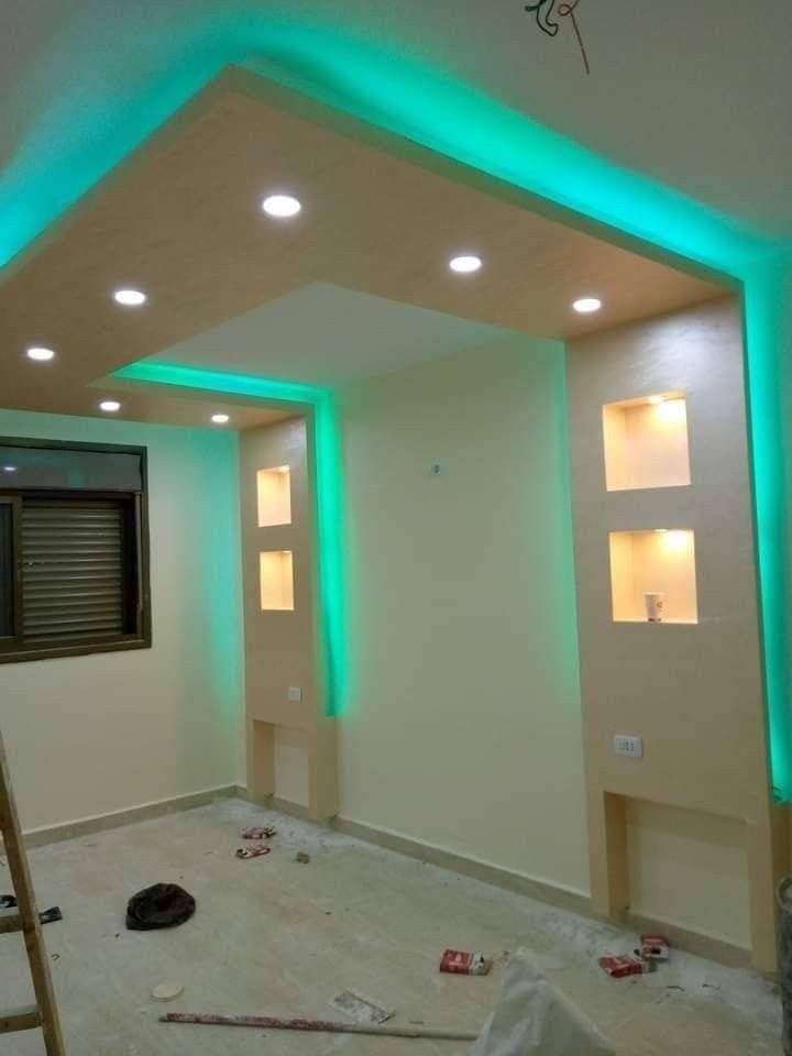 Interior de habitación moderna con luces de techo turquesas, nichos empotrados en la pared